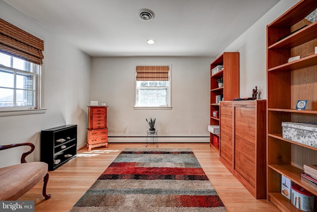 living area featuring light wood-type flooring, visible vents, a baseboard heating unit, and recessed lighting