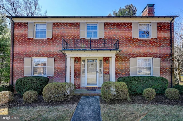 view of front of house with a chimney and brick siding