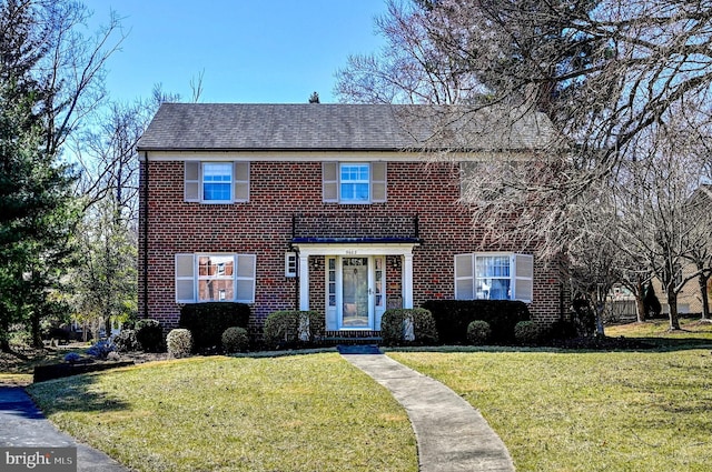 view of front of home featuring brick siding and a front yard