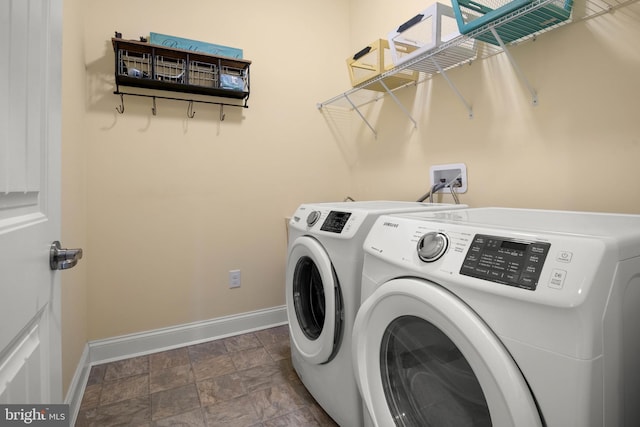 clothes washing area featuring laundry area, washer and clothes dryer, and baseboards