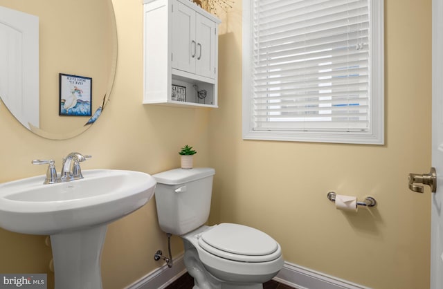 bathroom featuring baseboards and toilet