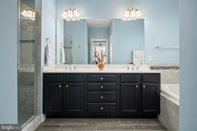 bathroom with double vanity, a stall shower, and a sink