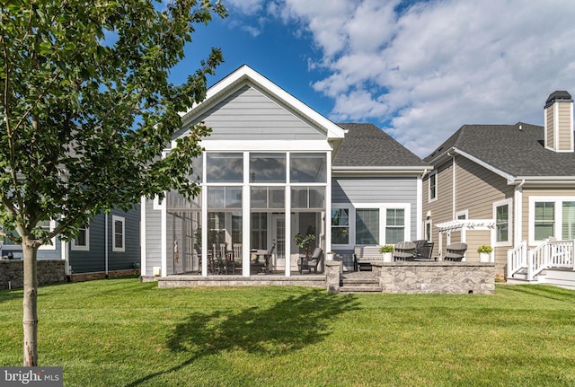 back of house featuring a sunroom, a patio area, a yard, and roof with shingles