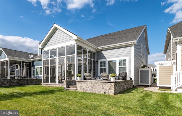 rear view of house featuring a sunroom, a patio area, and a yard