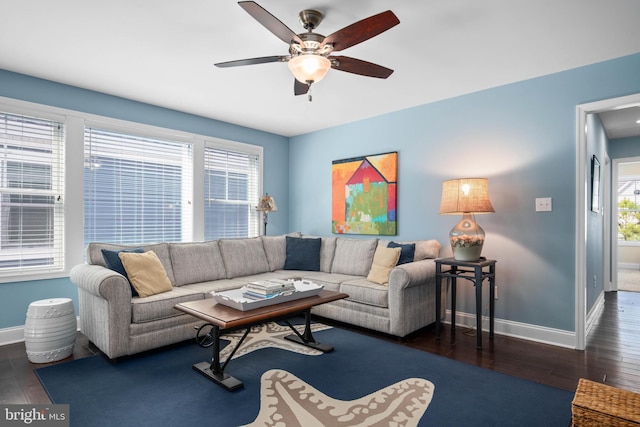 living room featuring wood finished floors, a ceiling fan, and baseboards