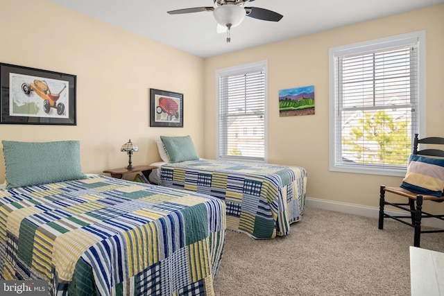 bedroom with a ceiling fan, carpet flooring, baseboards, and multiple windows