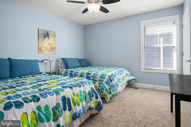 carpeted bedroom with ceiling fan and baseboards