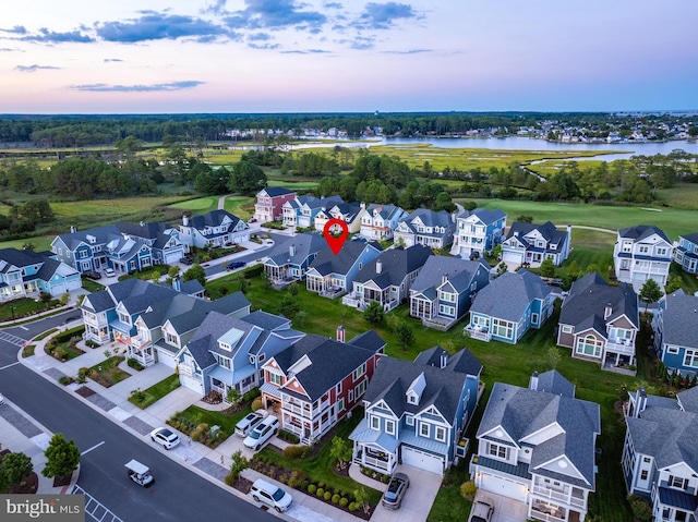 aerial view at dusk with a residential view and a water view