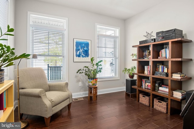 living area featuring visible vents, baseboards, and wood finished floors