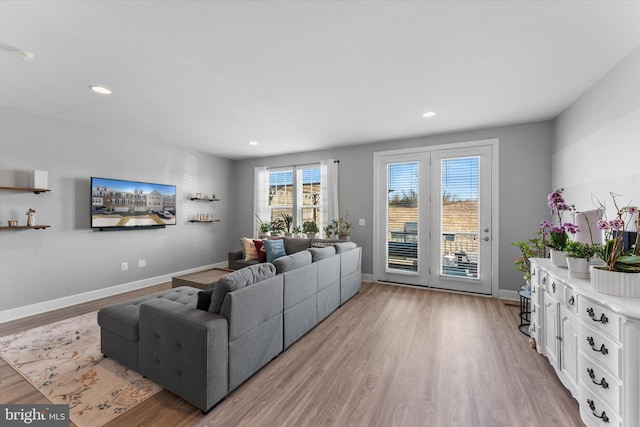 living room with recessed lighting, baseboards, and light wood finished floors