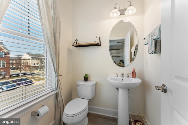 bathroom with a sink, toilet, baseboards, and wood finished floors