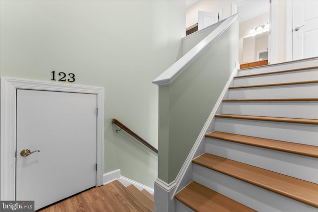 staircase with wood finished floors and baseboards