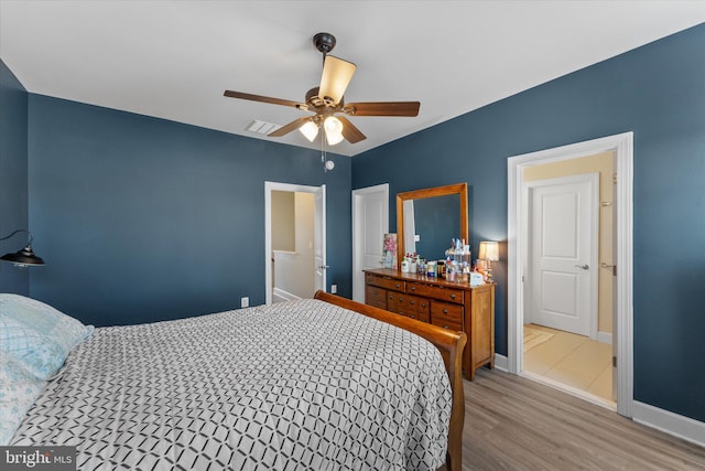 bedroom featuring wood finished floors, baseboards, visible vents, and ceiling fan