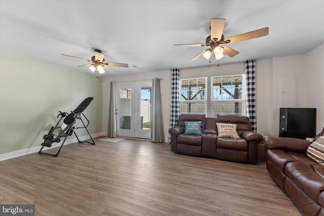 living area with plenty of natural light, baseboards, a ceiling fan, and wood finished floors