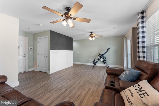 unfurnished living room with visible vents, baseboards, and wood finished floors