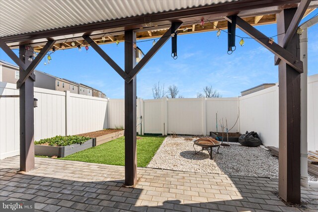 view of patio / terrace featuring a vegetable garden, an outdoor fire pit, and a fenced backyard