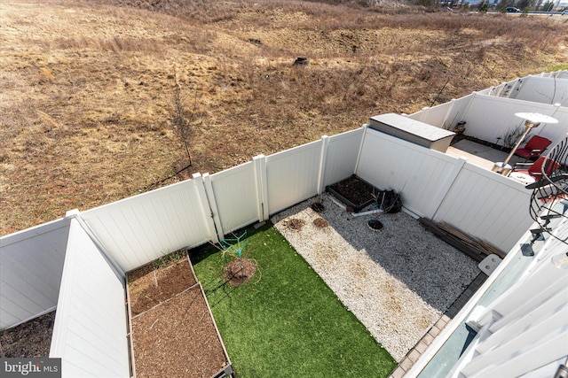 view of yard featuring a fenced backyard and a garden