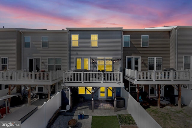 back of property featuring a fenced backyard, a patio, central AC unit, and a deck