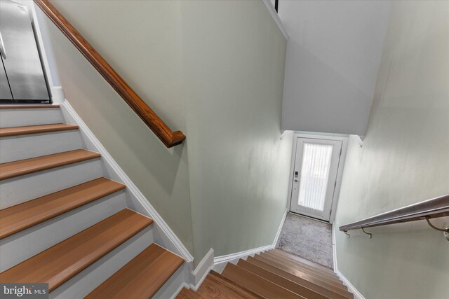 stairway with baseboards and wood finished floors