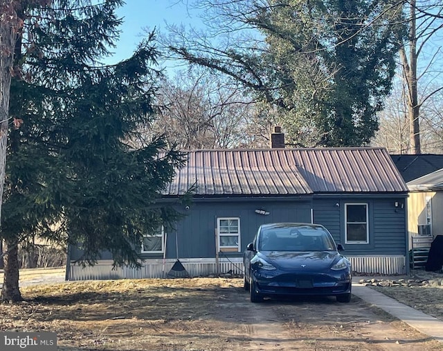 view of front of home with a chimney and metal roof