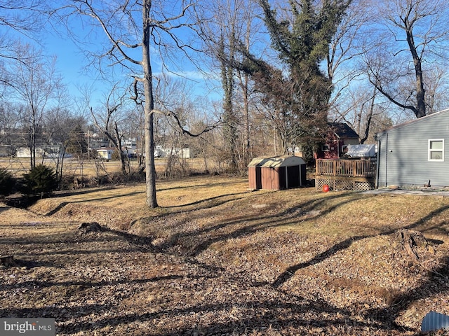 view of yard featuring an outdoor structure, a storage shed, and a deck