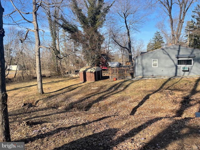 view of yard with a wooden deck, an outbuilding, and a shed