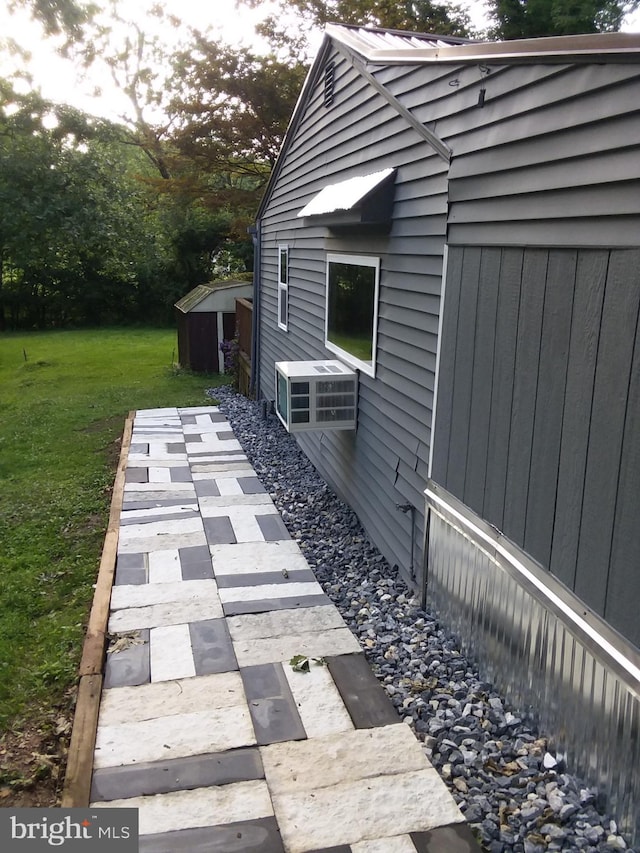 view of home's exterior with a yard, a storage shed, and an outdoor structure