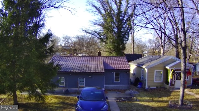 ranch-style house with a chimney and metal roof