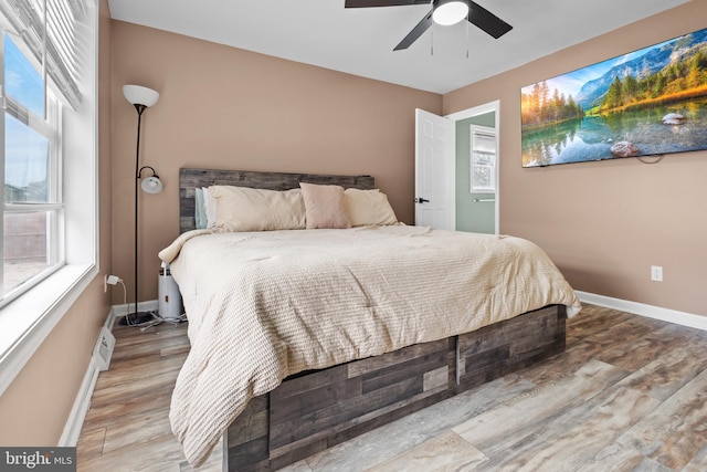 bedroom featuring ceiling fan, baseboards, and wood finished floors