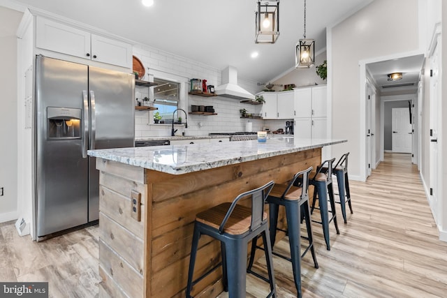 kitchen featuring stainless steel fridge, decorative backsplash, open shelves, and premium range hood