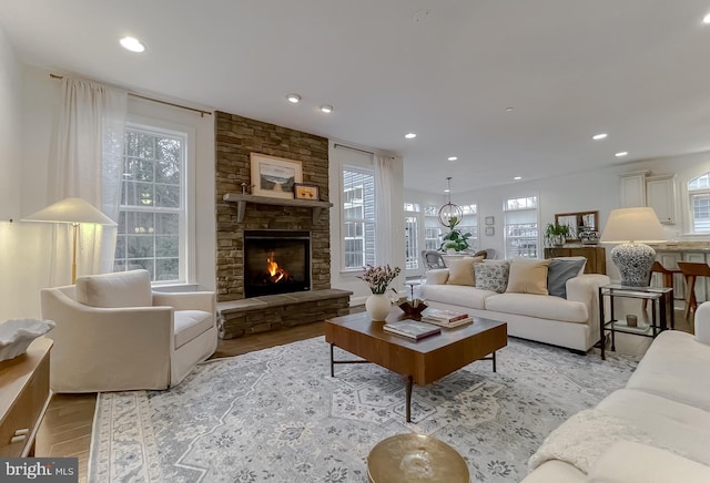 living room with recessed lighting, light wood-type flooring, plenty of natural light, and a fireplace