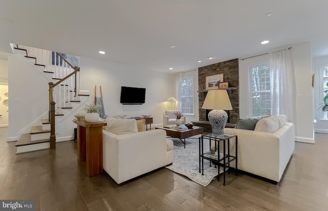 living room with a healthy amount of sunlight, wood finished floors, and stairs