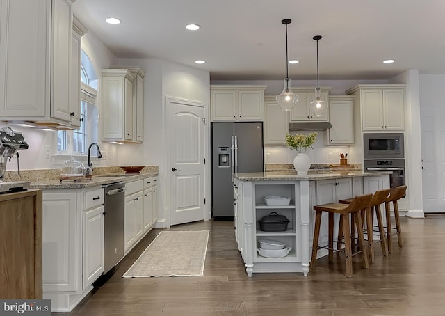 kitchen featuring open shelves, a sink, under cabinet range hood, appliances with stainless steel finishes, and light stone countertops