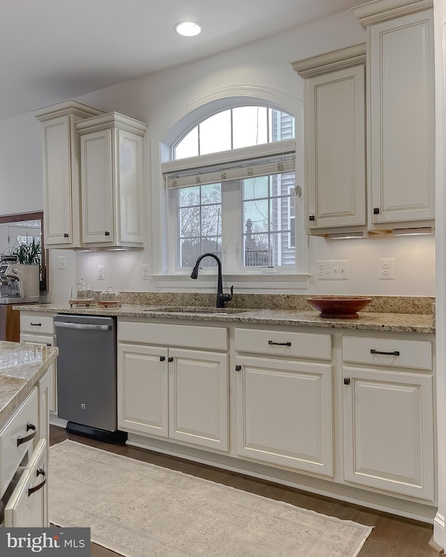 kitchen with a sink, light stone countertops, stainless steel dishwasher, and recessed lighting