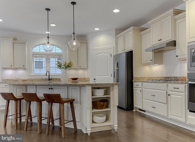 kitchen featuring a kitchen island, under cabinet range hood, recessed lighting, stainless steel appliances, and open shelves