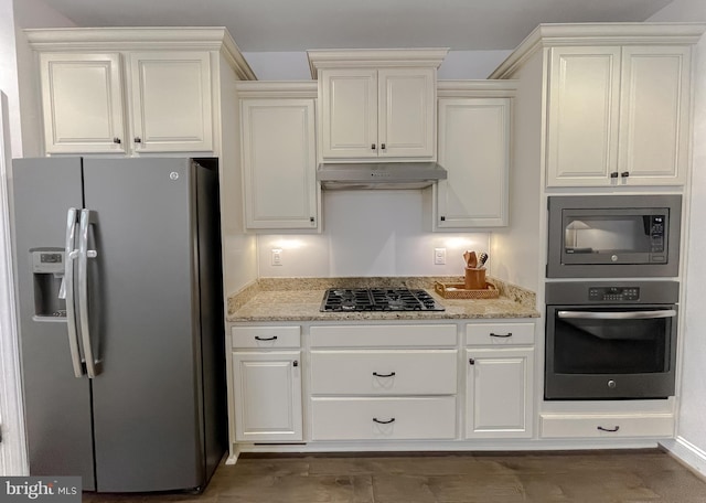 kitchen featuring white cabinets, light stone countertops, under cabinet range hood, and stainless steel appliances