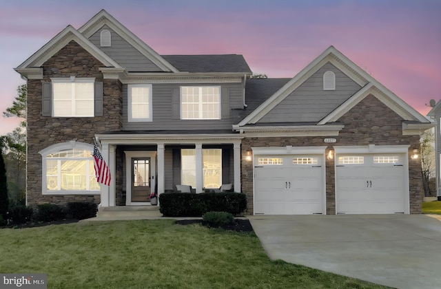 view of front of house featuring a front yard, a porch, a garage, and driveway