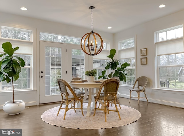 dining space with recessed lighting, baseboards, wood-type flooring, and a chandelier