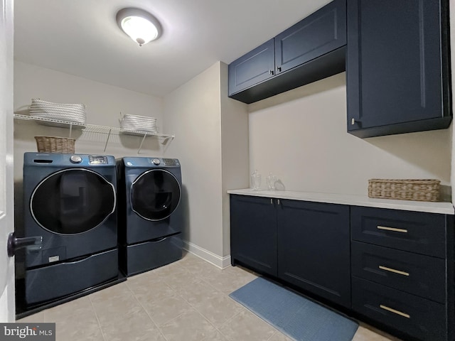 washroom featuring baseboards, cabinet space, separate washer and dryer, and light tile patterned flooring