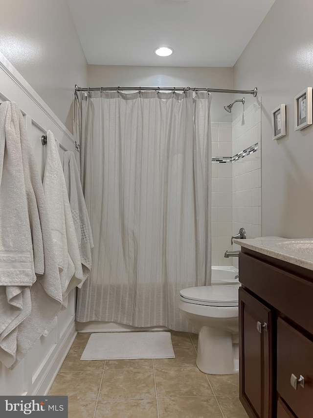 full bathroom featuring shower / bath combo with shower curtain, toilet, vanity, and tile patterned flooring