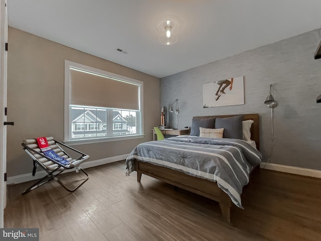 bedroom featuring visible vents, wood finished floors, and baseboards