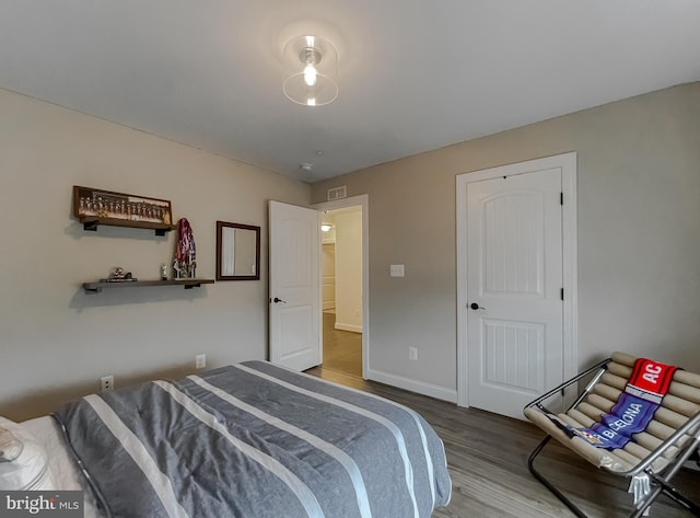 bedroom featuring visible vents, wood finished floors, and baseboards