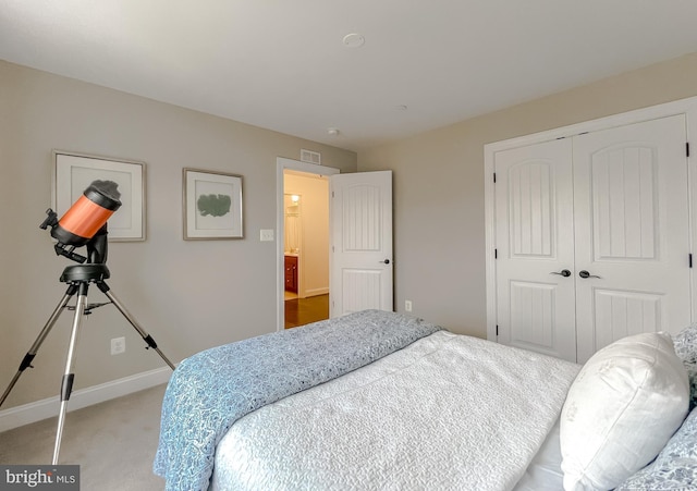 bedroom with visible vents, baseboards, a closet, and light carpet