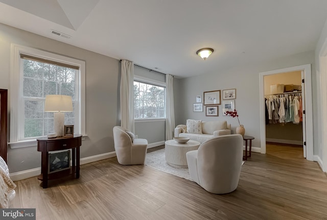 living room with visible vents, baseboards, and wood finished floors