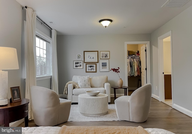 living room with visible vents, baseboards, and wood finished floors