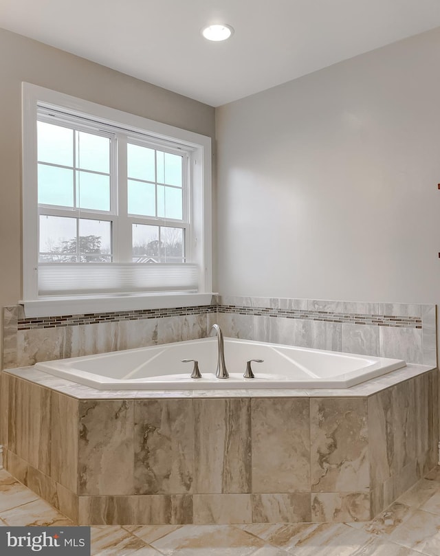 full bathroom with a healthy amount of sunlight and a bath