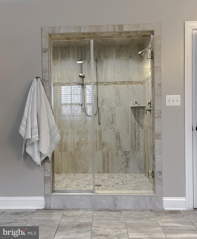 bathroom with a stall shower and baseboards