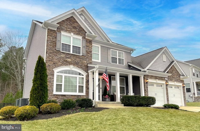 view of front of house featuring a front yard, cooling unit, driveway, stone siding, and a garage