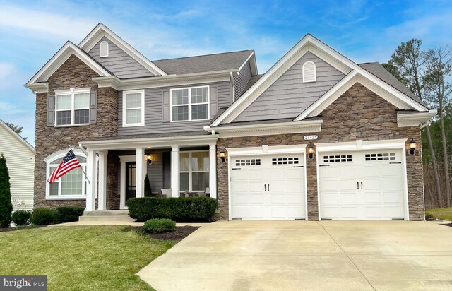 craftsman-style house with concrete driveway, a porch, a garage, and a front lawn