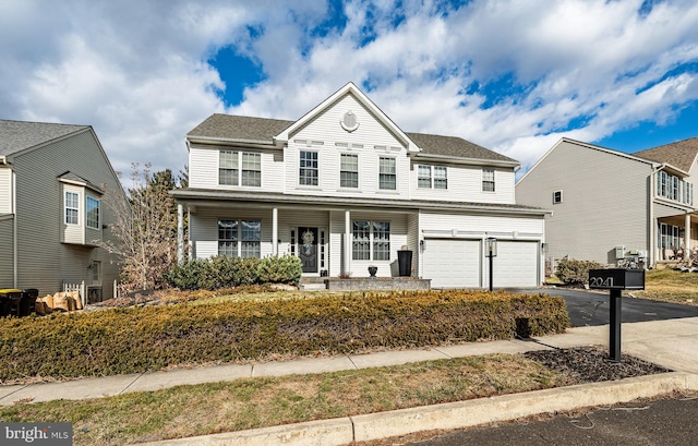 view of front of property with an attached garage, covered porch, and driveway